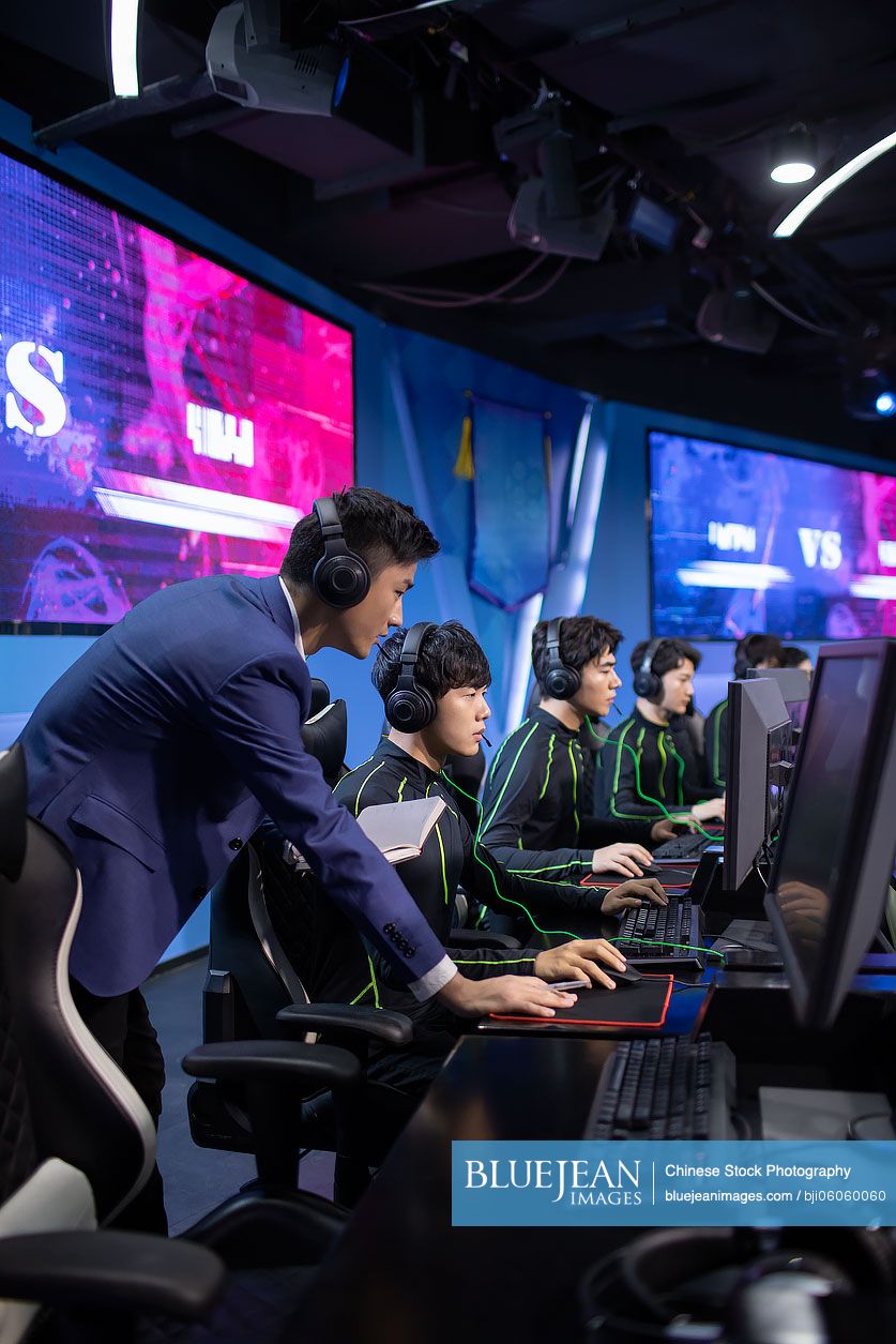 Young chinese man coaching gamer playing esports high res stock photo
