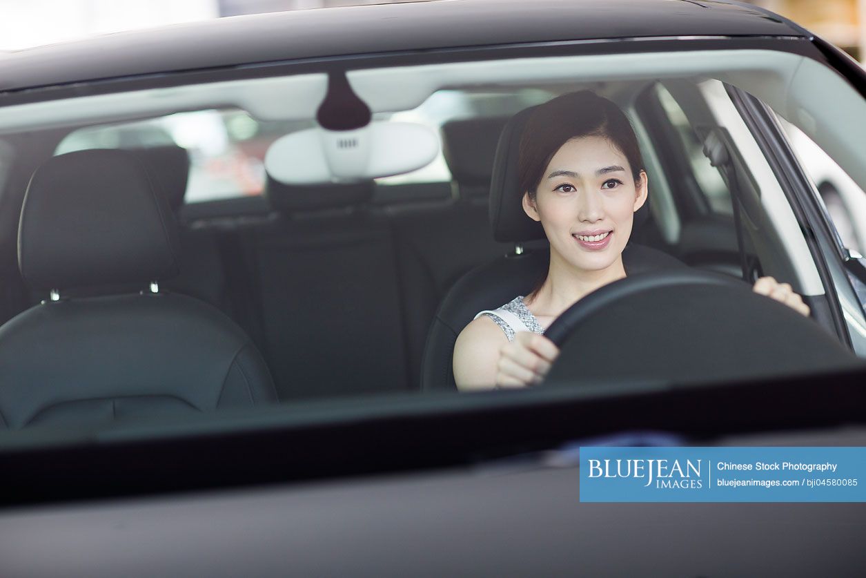 Young Chinese woman taking a test drive