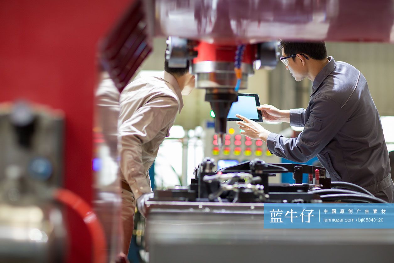 年轻工程师在工厂讨论工作