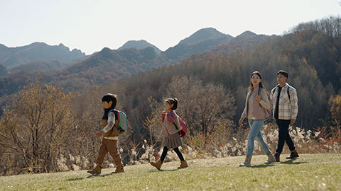 Happy young Chinese family hiking outdoors