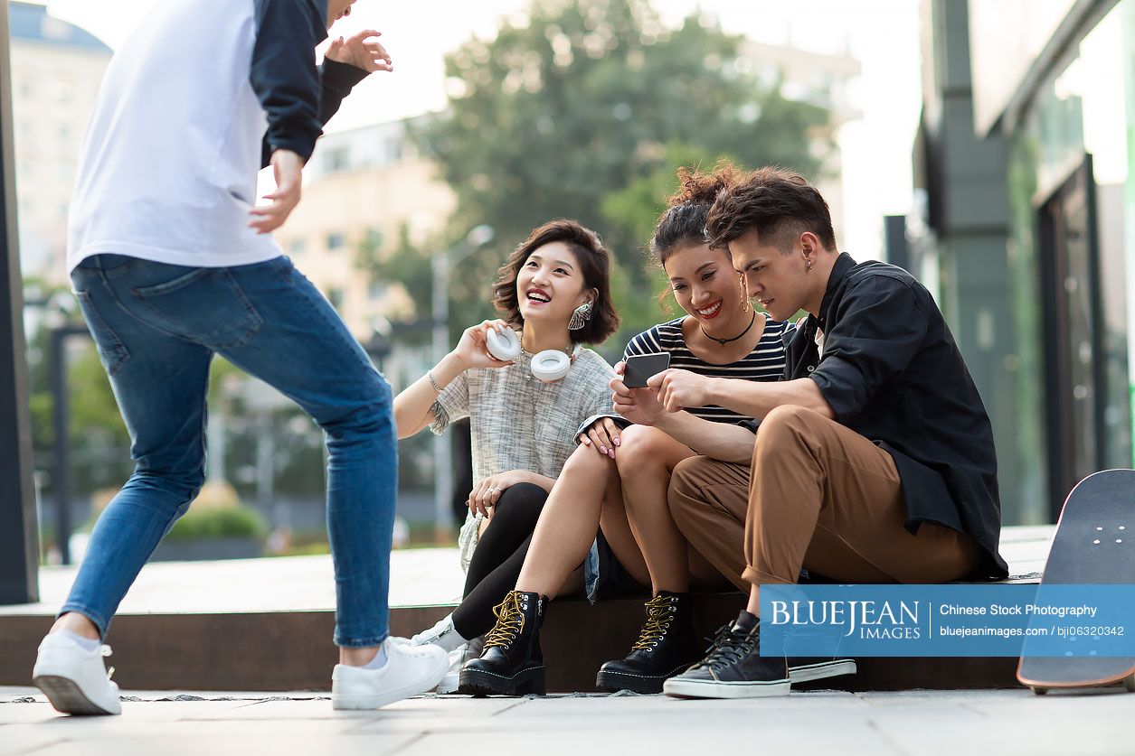 Happy young Chinese friends having fun outdoors