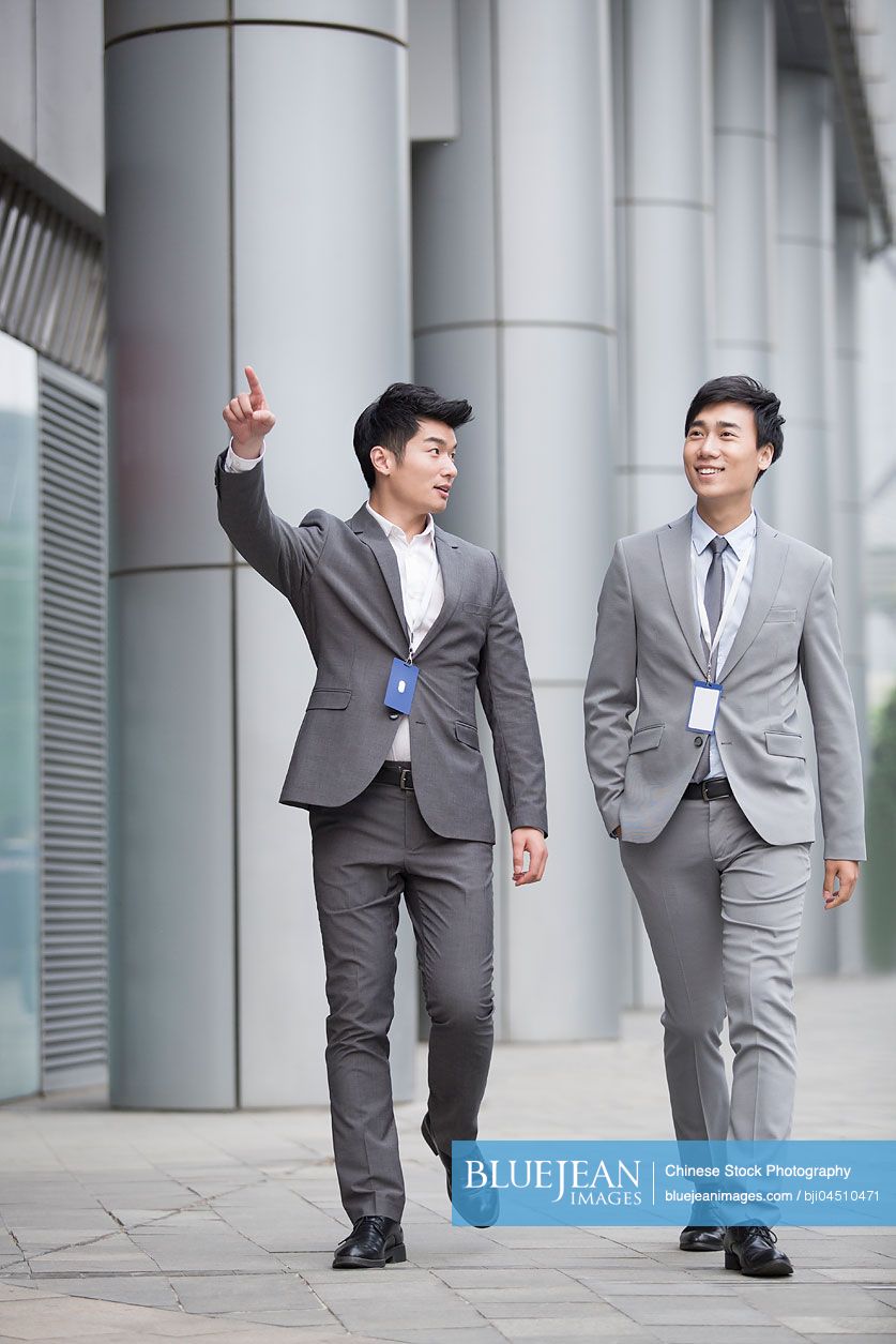 Young Chinese business person talking outdoors