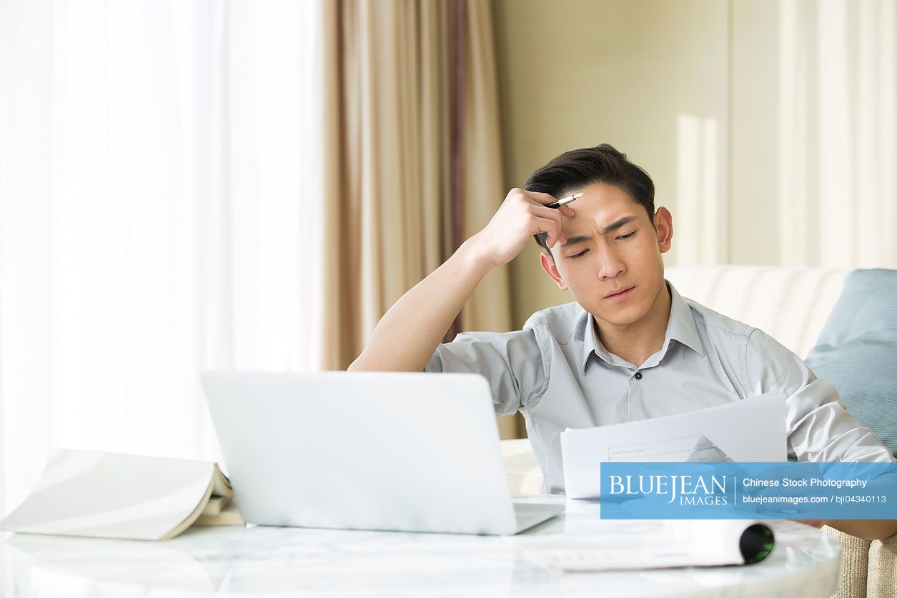 Young Chinese man working at home