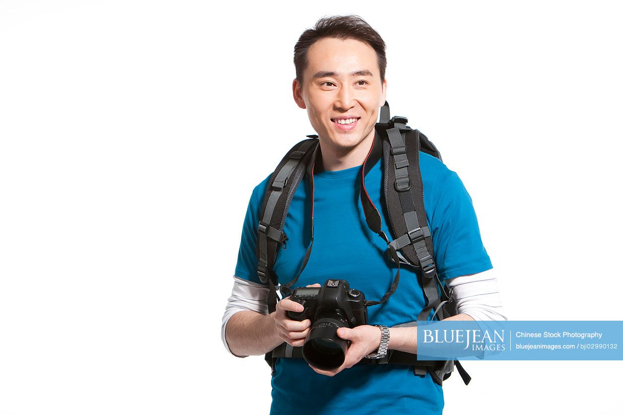 Portrait of a young Chinese man holding a camera