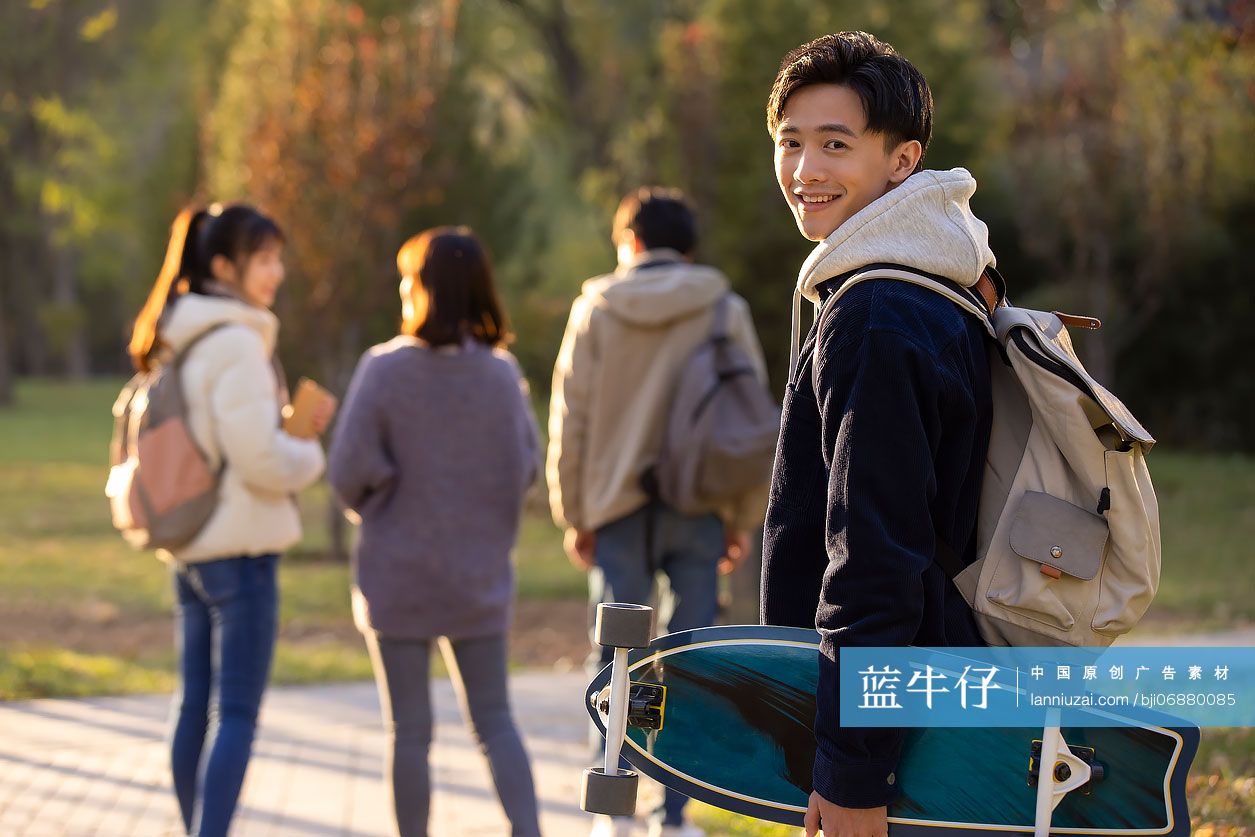 校园里拿着滑板的大学生