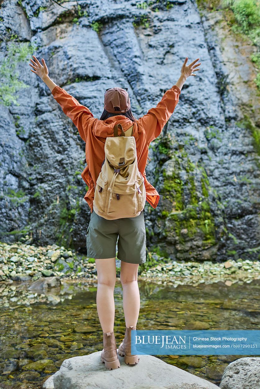 Happy young woman hiking through the serene beauty of nature