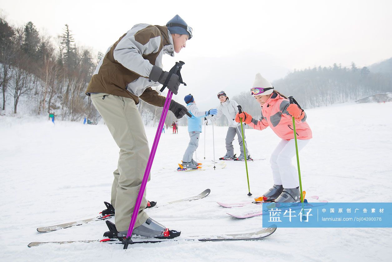 年轻的父母教子女滑雪