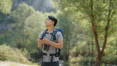 Young Chinese man hiking outdoors