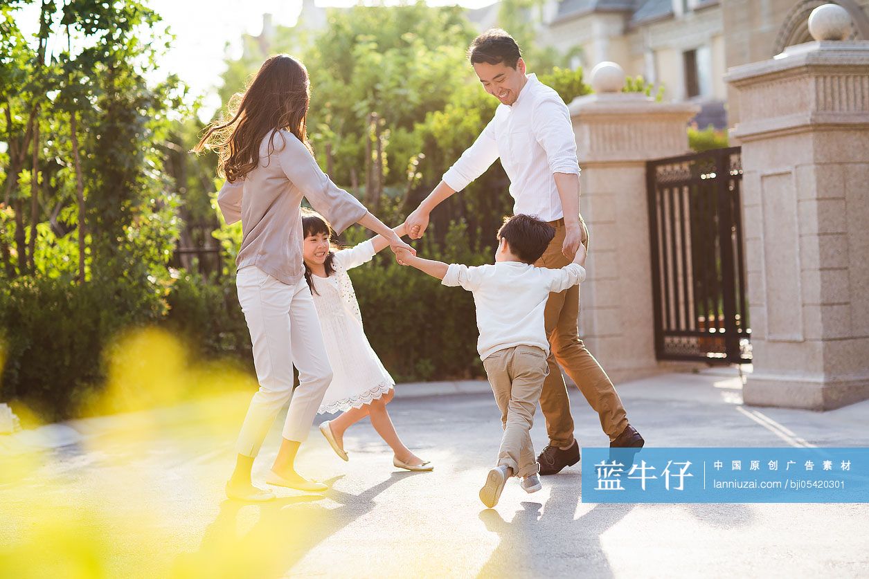 快乐的年轻家庭在别墅外玩耍