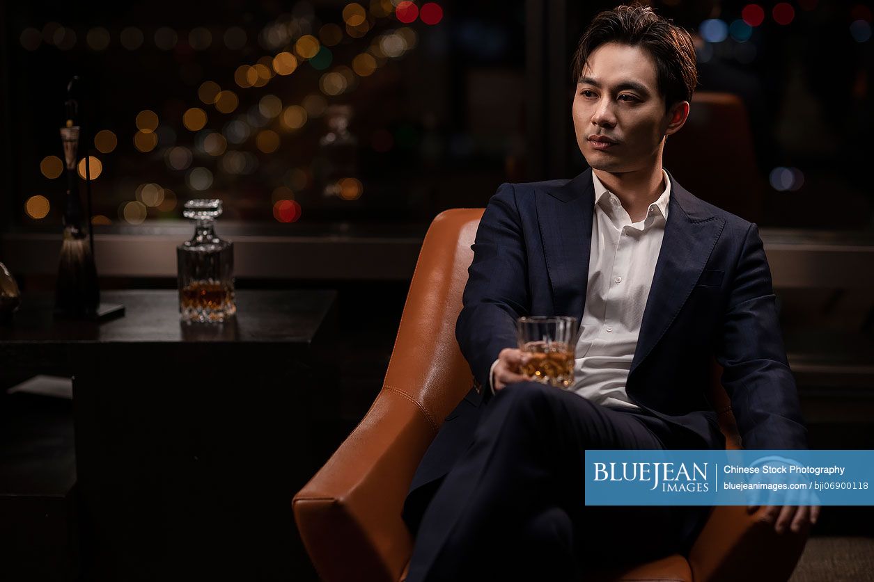 Elegant Chinese man drinking whiskey