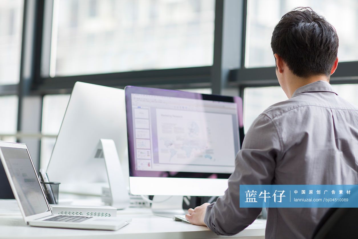 年轻商务男士在办公室使用电脑