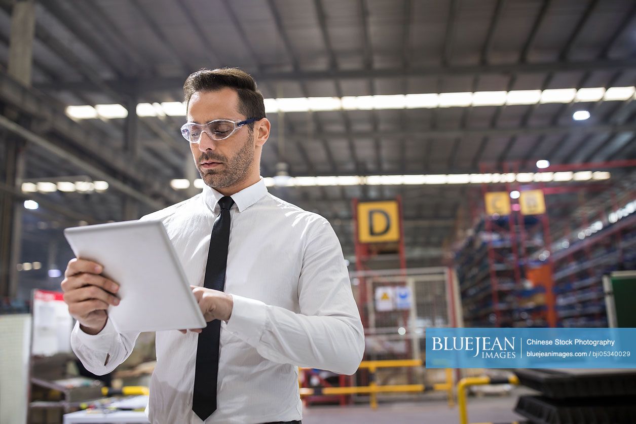 Businessman holding a digital tablet in the factory