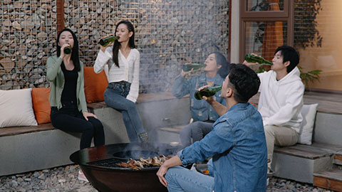 Happy young Chinese friends barbecuing outdoors,4K