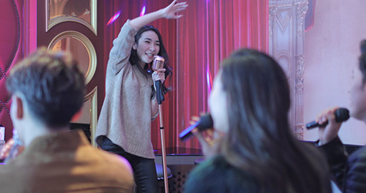 Happy young Chinese friends singing karaoke in nightclub,4k