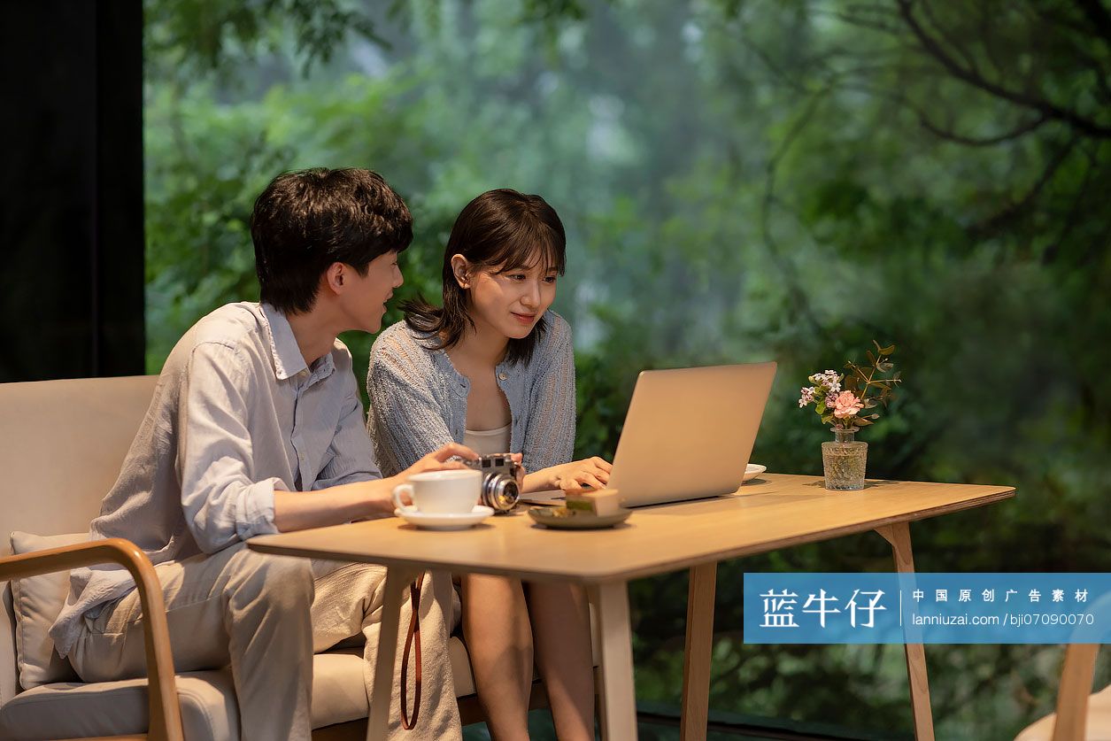 年轻情侣在咖啡馆使用笔记本电脑-蓝牛仔影像-中国原创广告影像素材