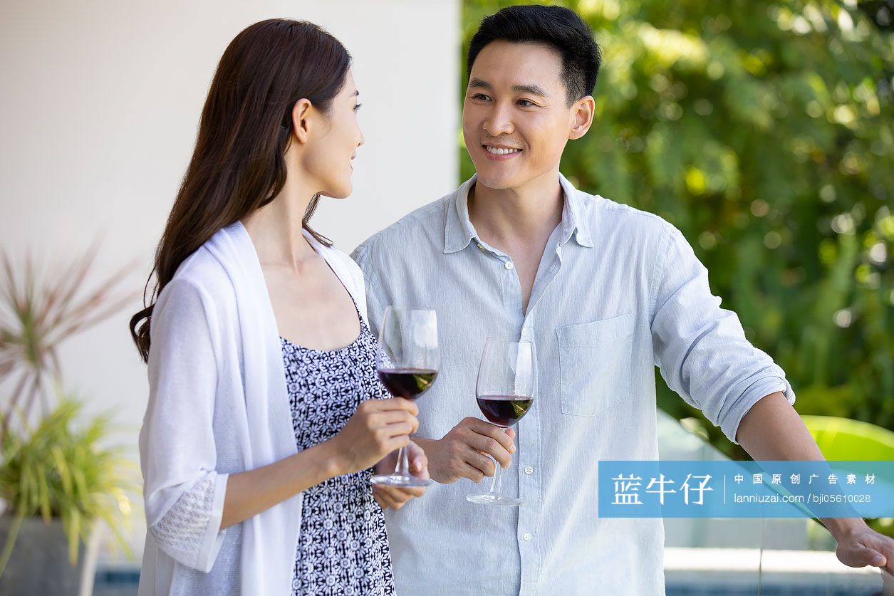 年轻夫妇在露台喝红酒