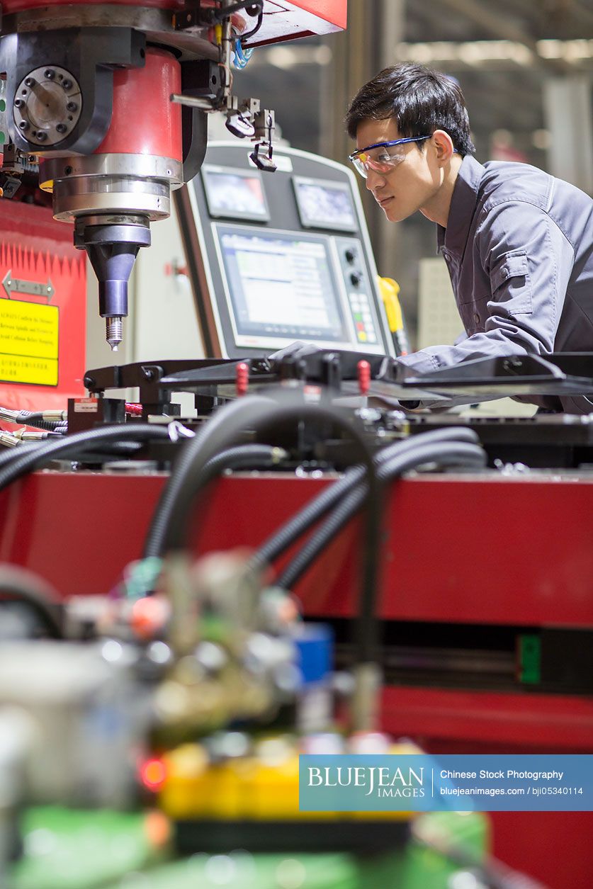 Young Chinese engineer working in the factory