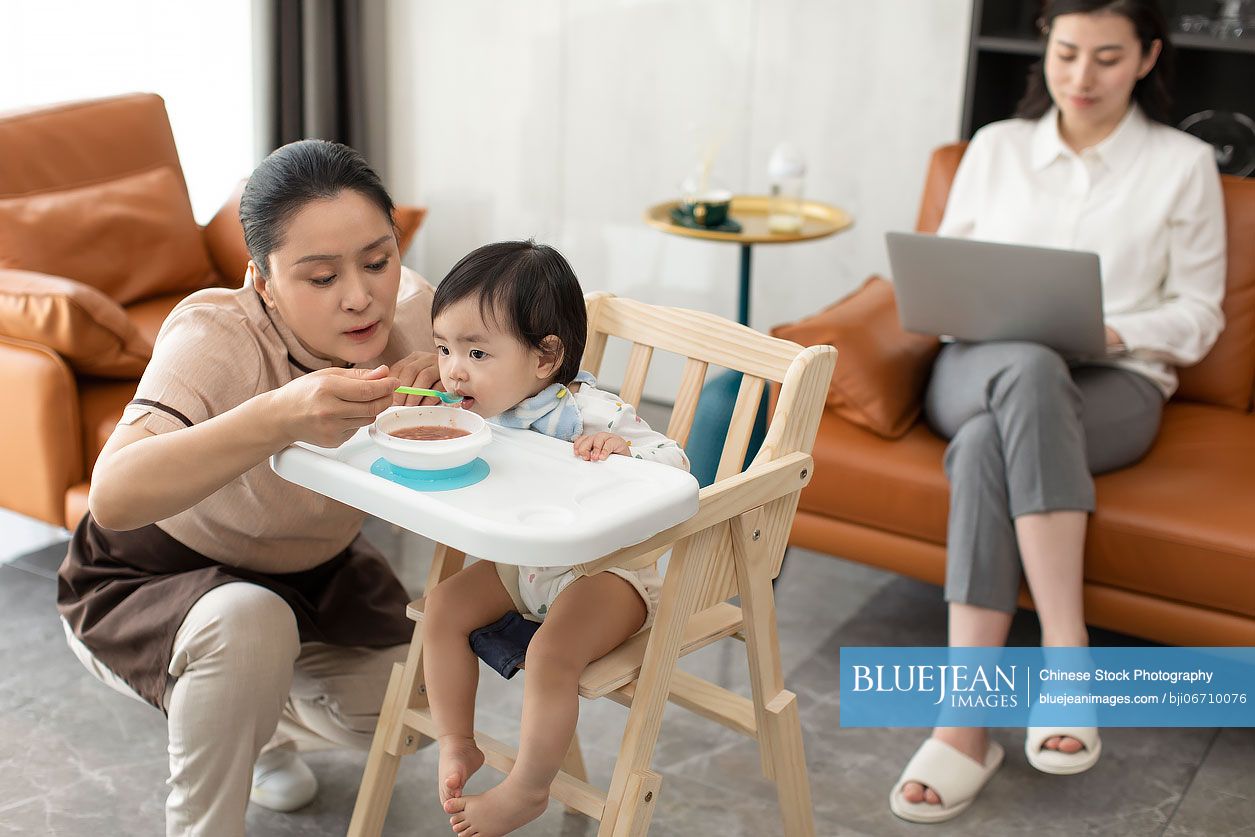 Chinese nanny taking care of baby girl