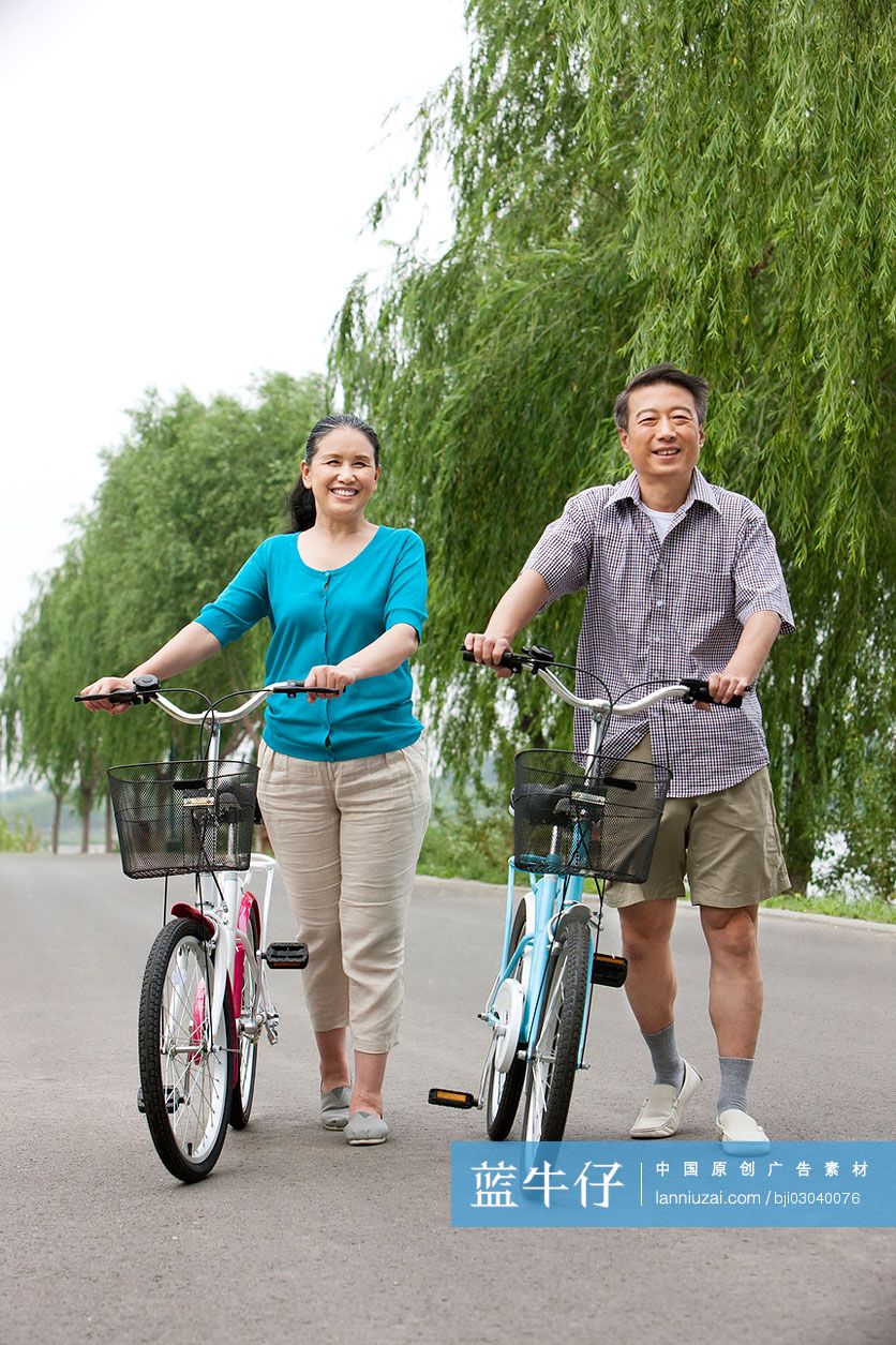 老年夫妻公园内骑自行车