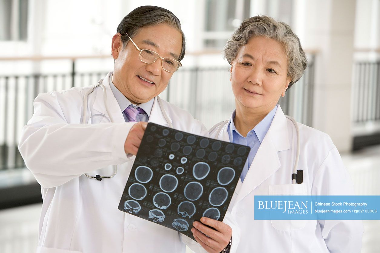Two Chinese doctors examining a CAT scan