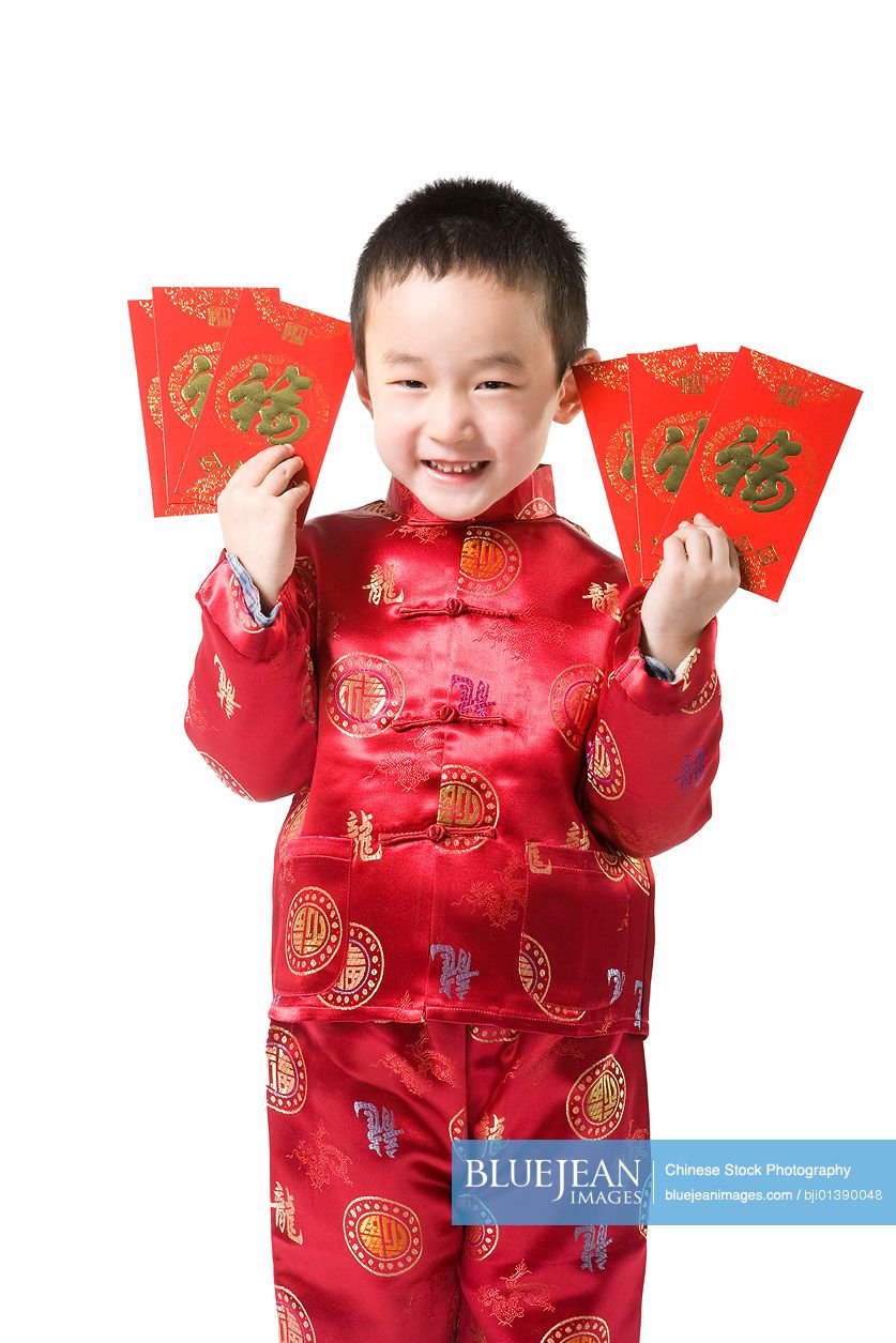 Boy in Chinese traditional clothes holding red envelop