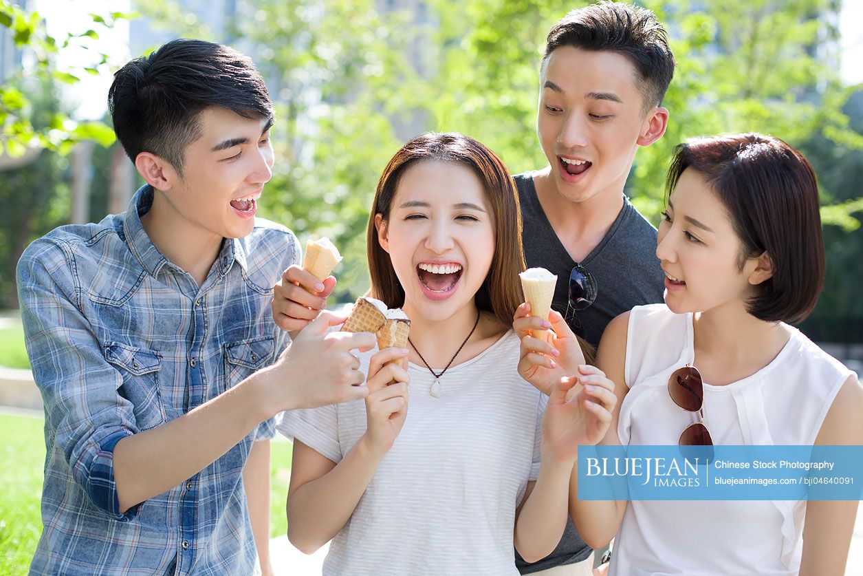 Happy young Chinese adults eating ice cream