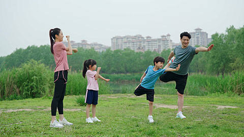 一家人在公园草坪上拉伸