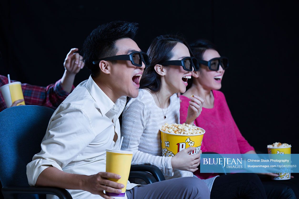 Young Chinese couple watching 3D movie in cinema