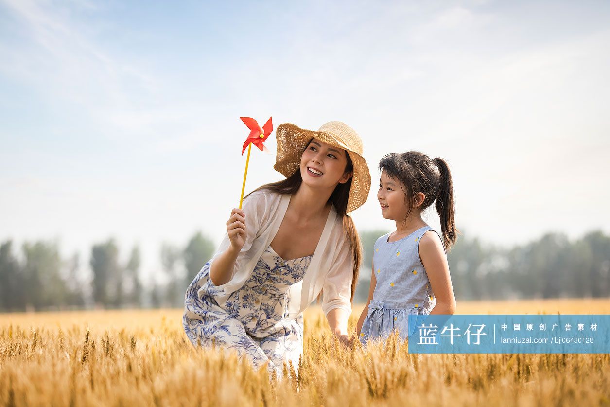 快乐的母女俩在麦田里玩耍