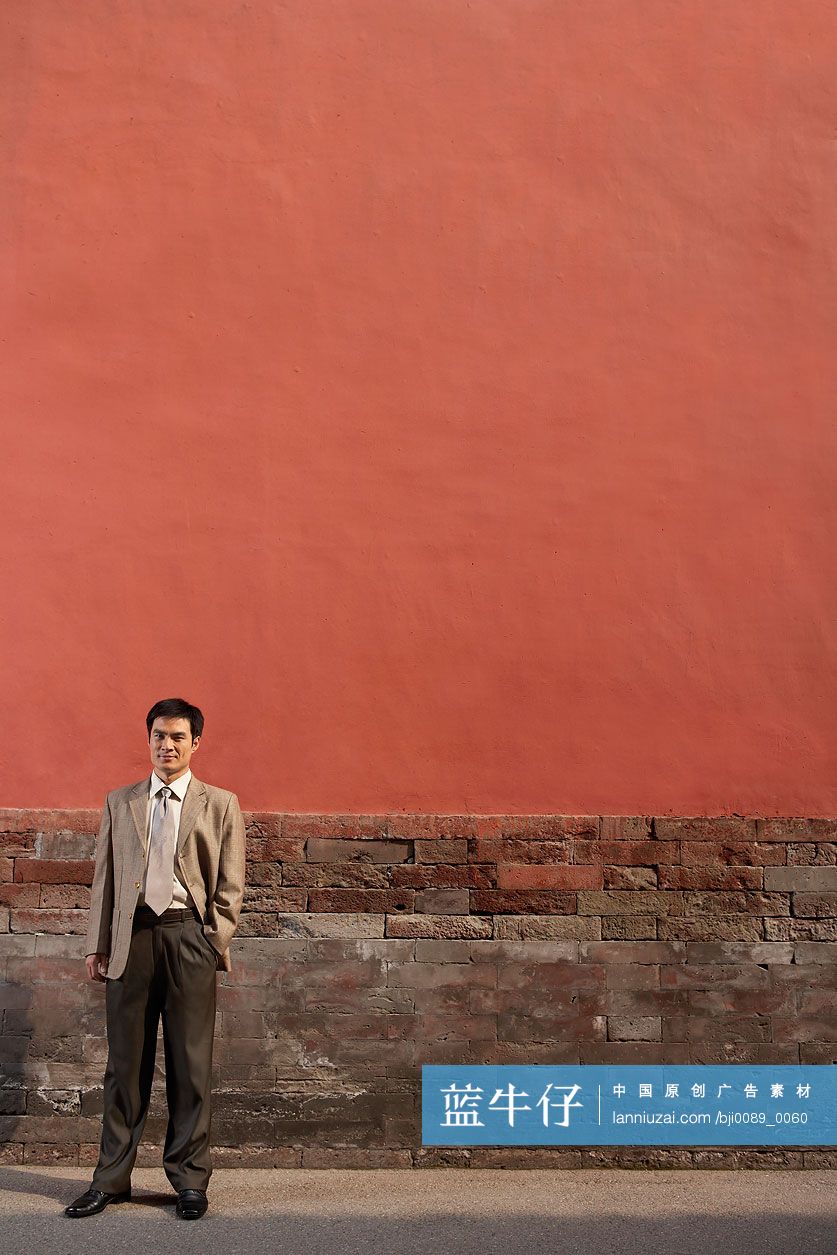 商务男士站在宫墙下