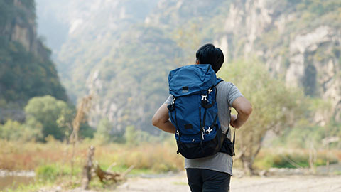 Young Chinese man hiking outdoors