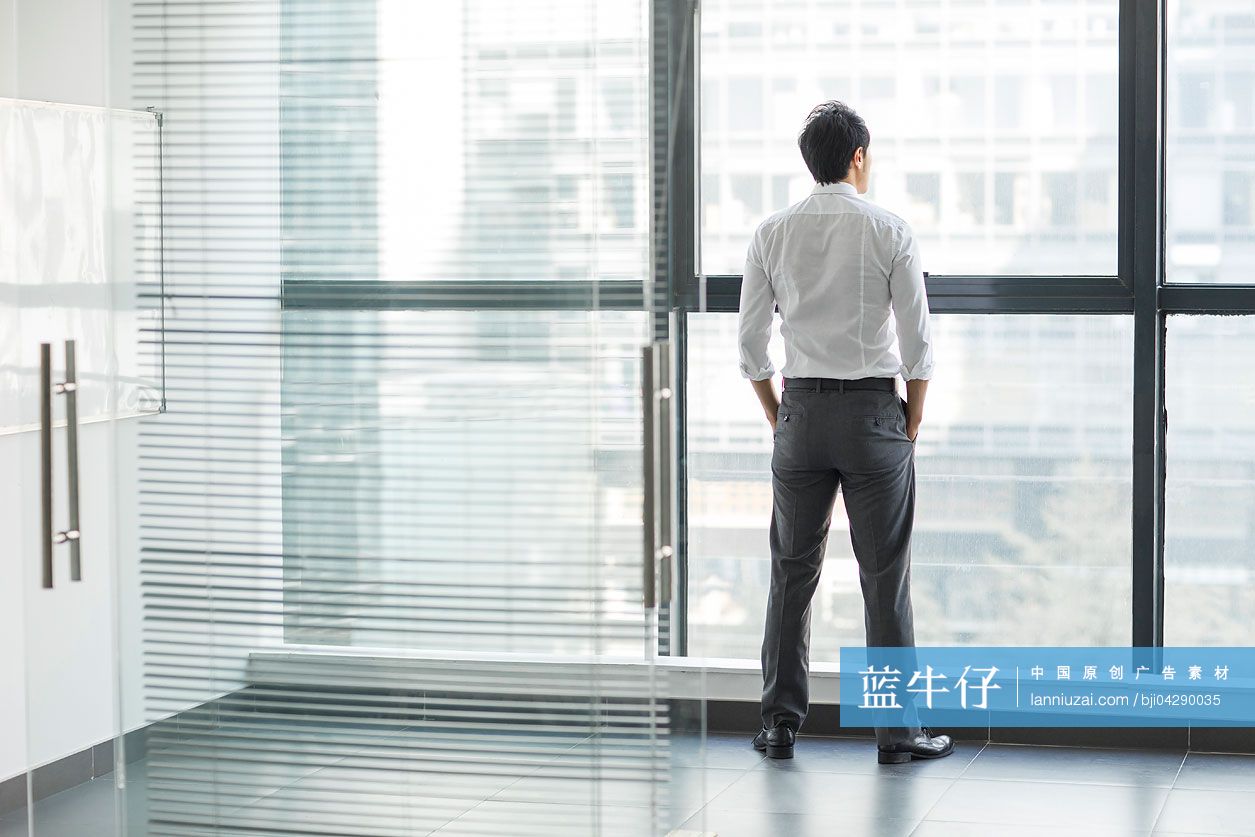 商务男士向办公室窗外望去