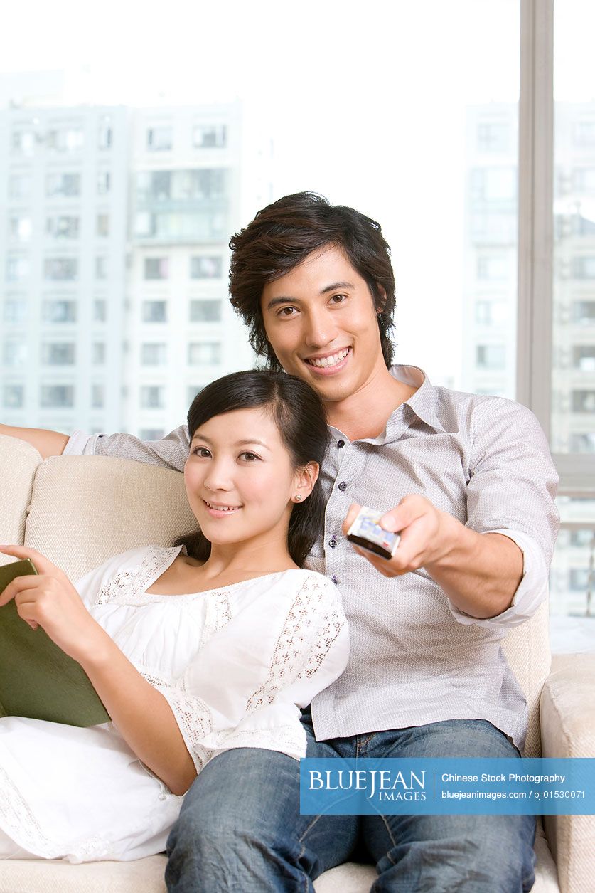 Chinese couple cuddling on a sofa