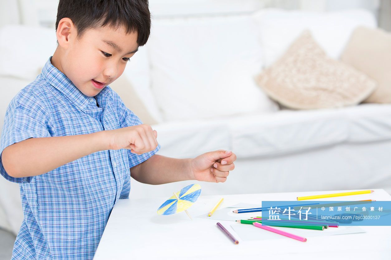 小男孩在做纸玩具