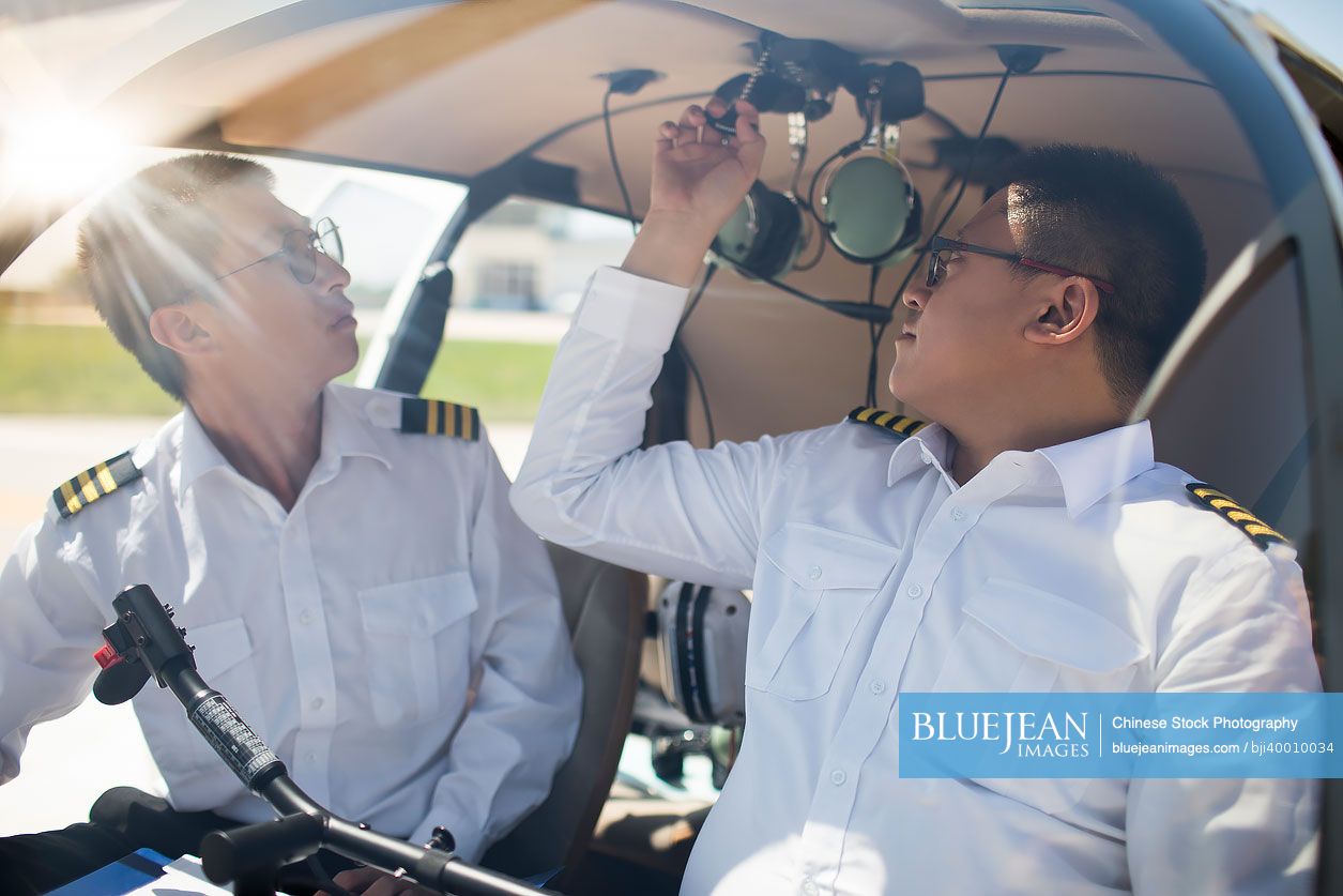 Chinese pilot teaching trainee to operate control panel in cockpit-High ...