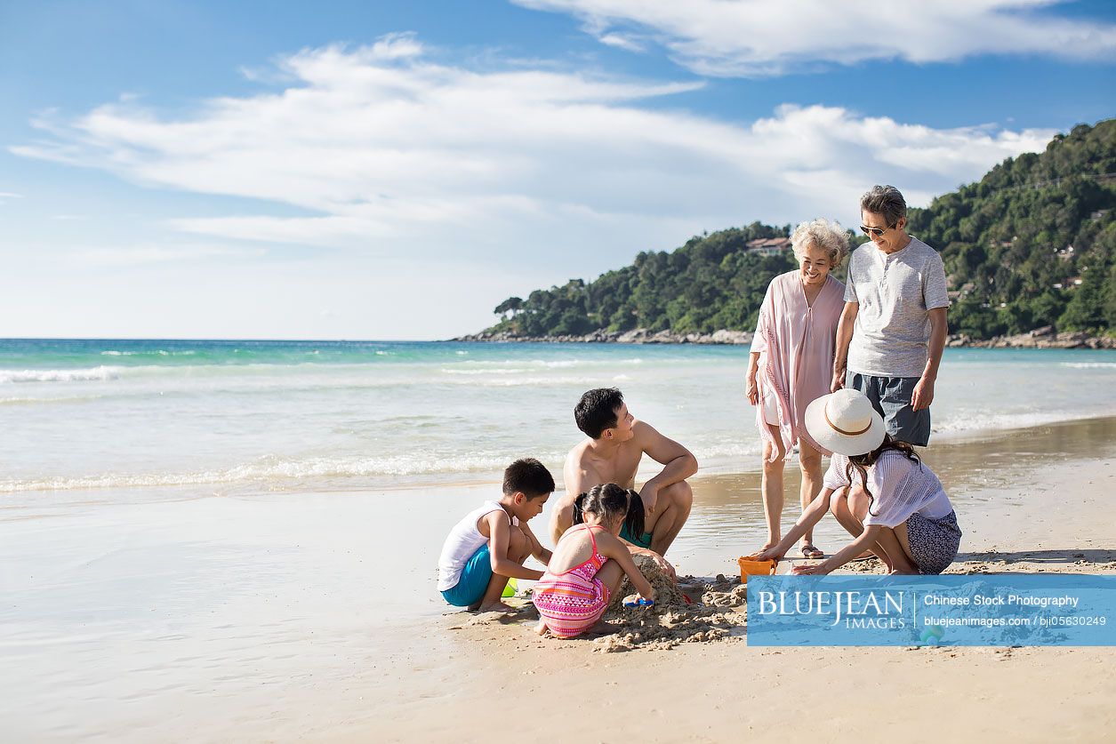 Happy Chinese family having fun on beach