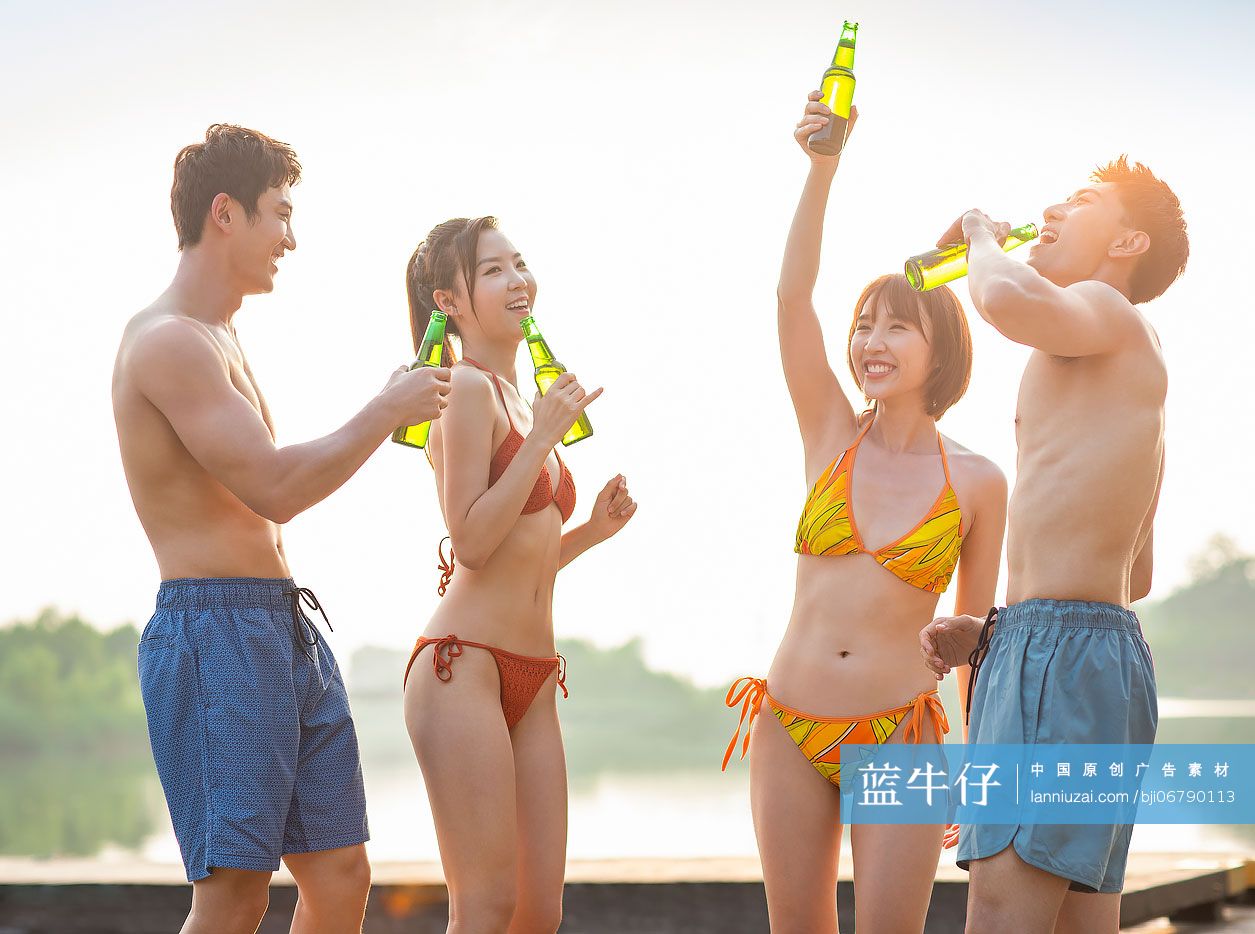 快乐的年轻人在湖边喝啤酒