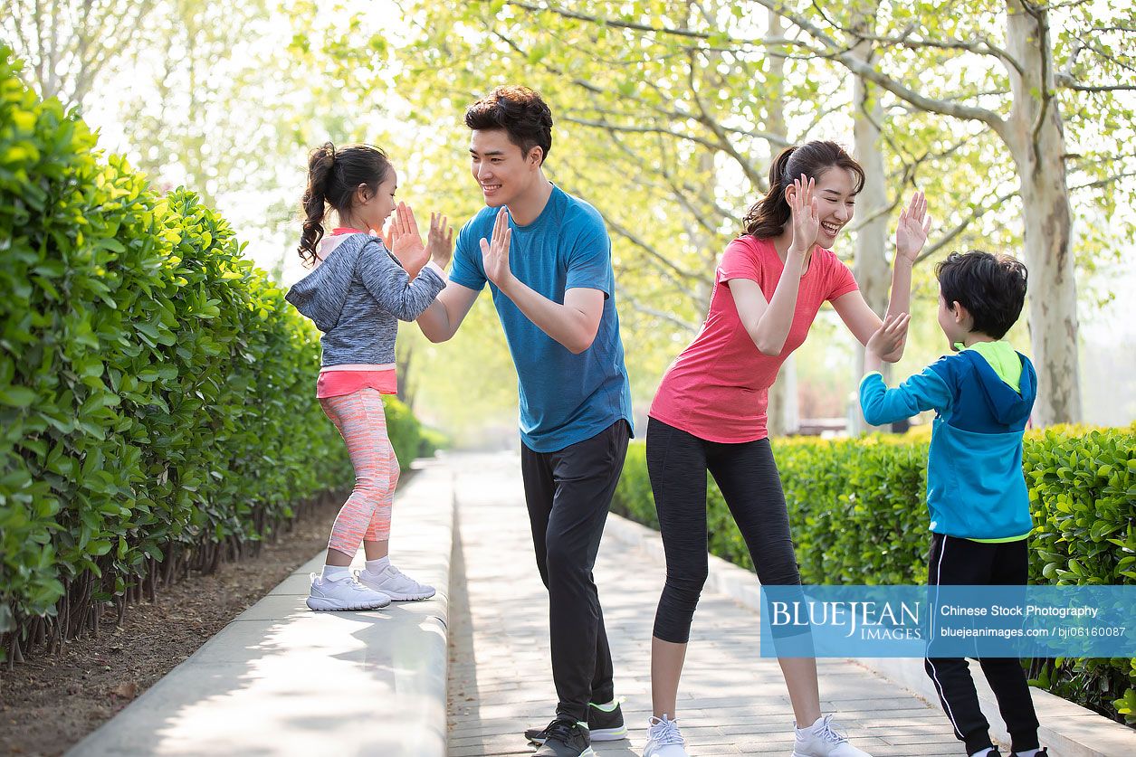 Happy young Chinese family having fun in park