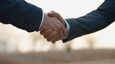 Confident Chinese businessmen shaking hands outdoors