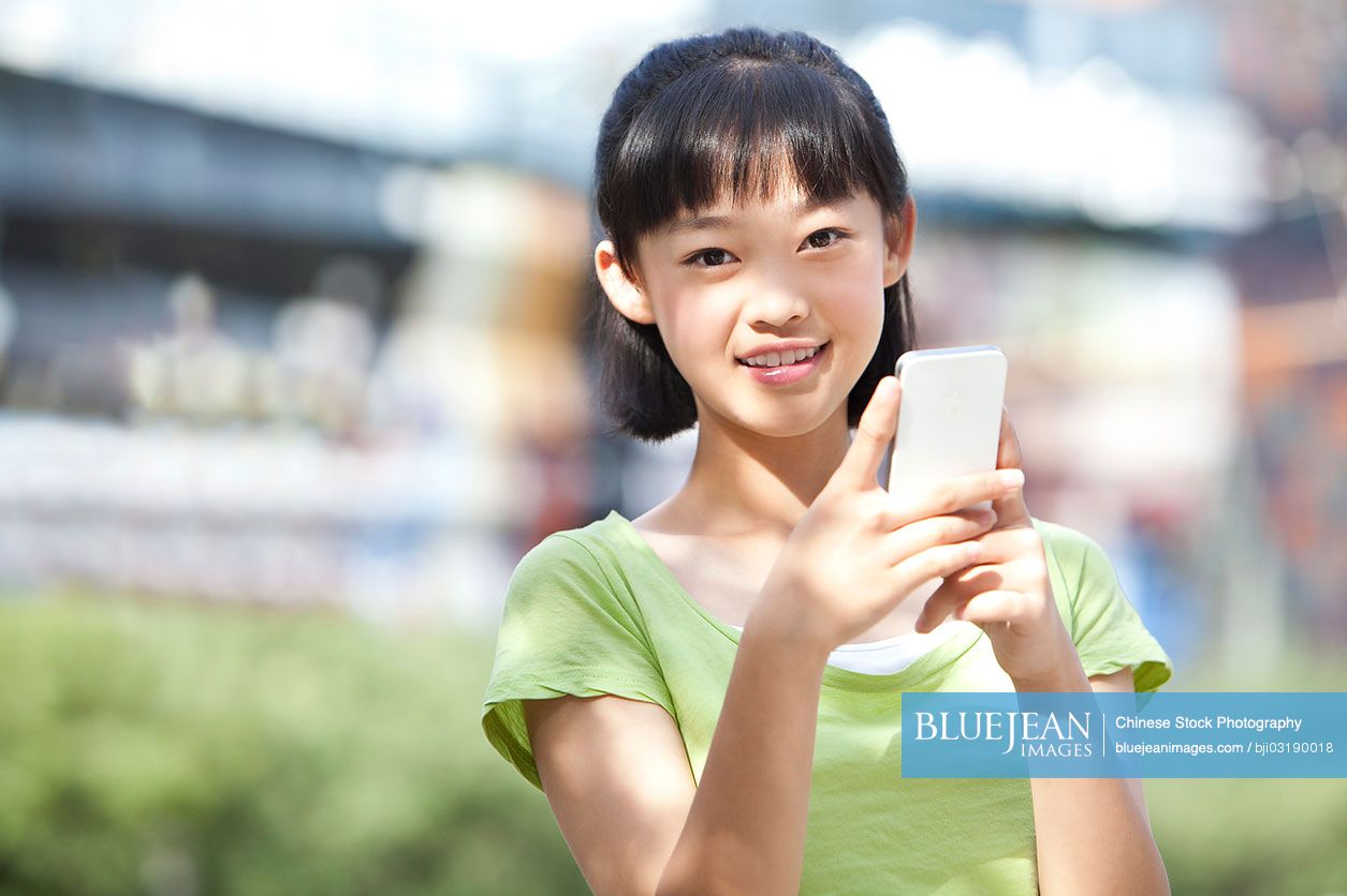 Portrait of Chinese schoolgirl holding smart phone