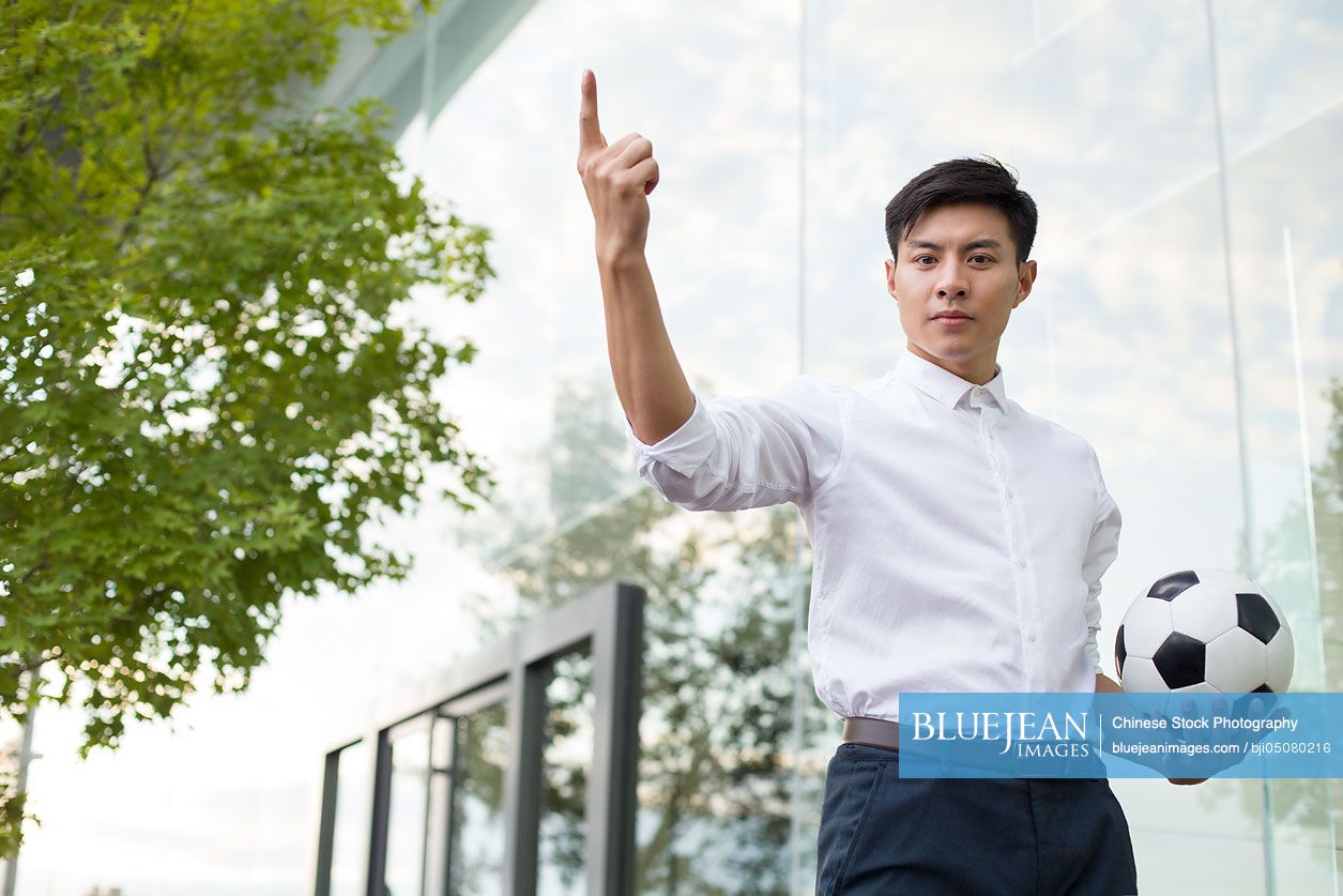 Young Chinese businessman holding a soccer ball-High-res stock photo ...