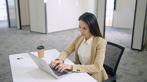 Chinese businesswoman using laptop in empty office