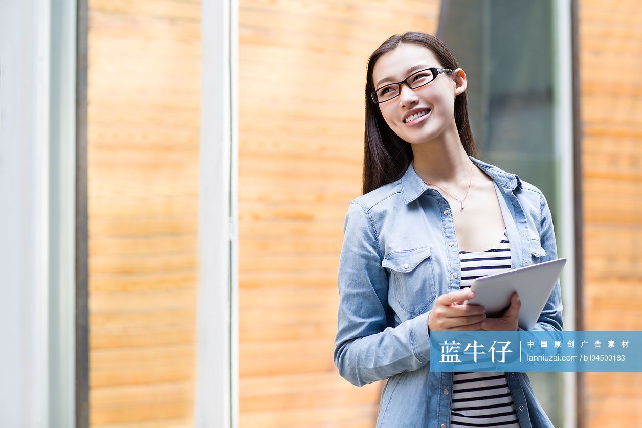 年轻女子拿着平板电脑