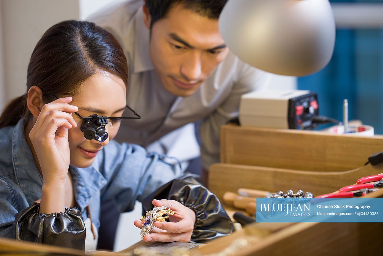 Chinese jeweler examining jewelry with loupeHighres stock photo for