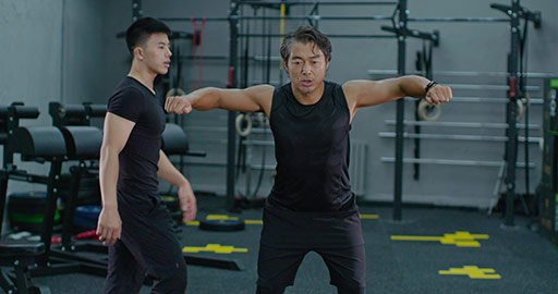 Mature Chinese man working out with personal trainer at gym,4K