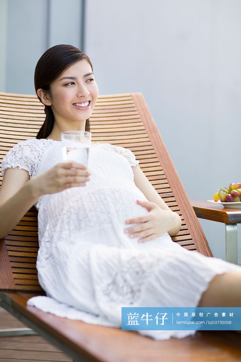 孕妇靠在躺椅上喝水