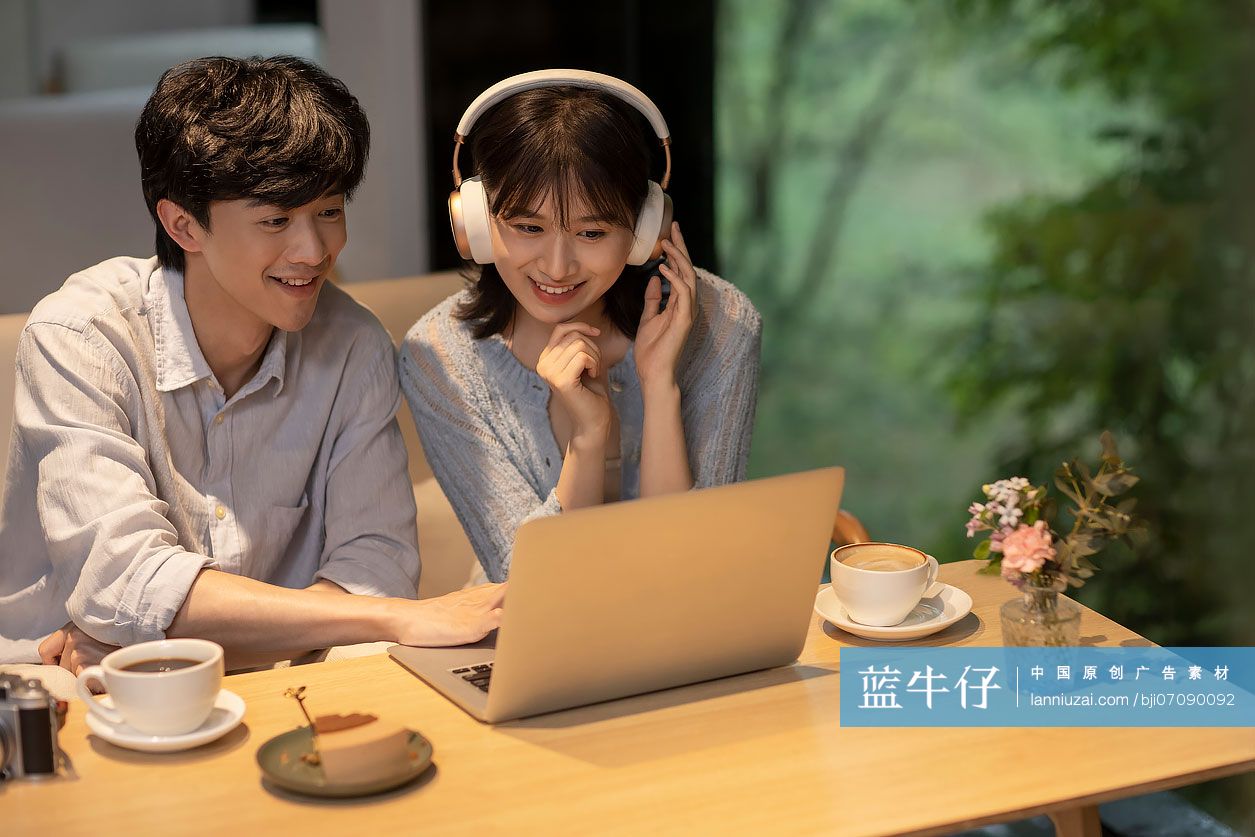 年轻情侣在咖啡馆使用笔记本电脑-蓝牛仔影像-中国原创广告影像素材