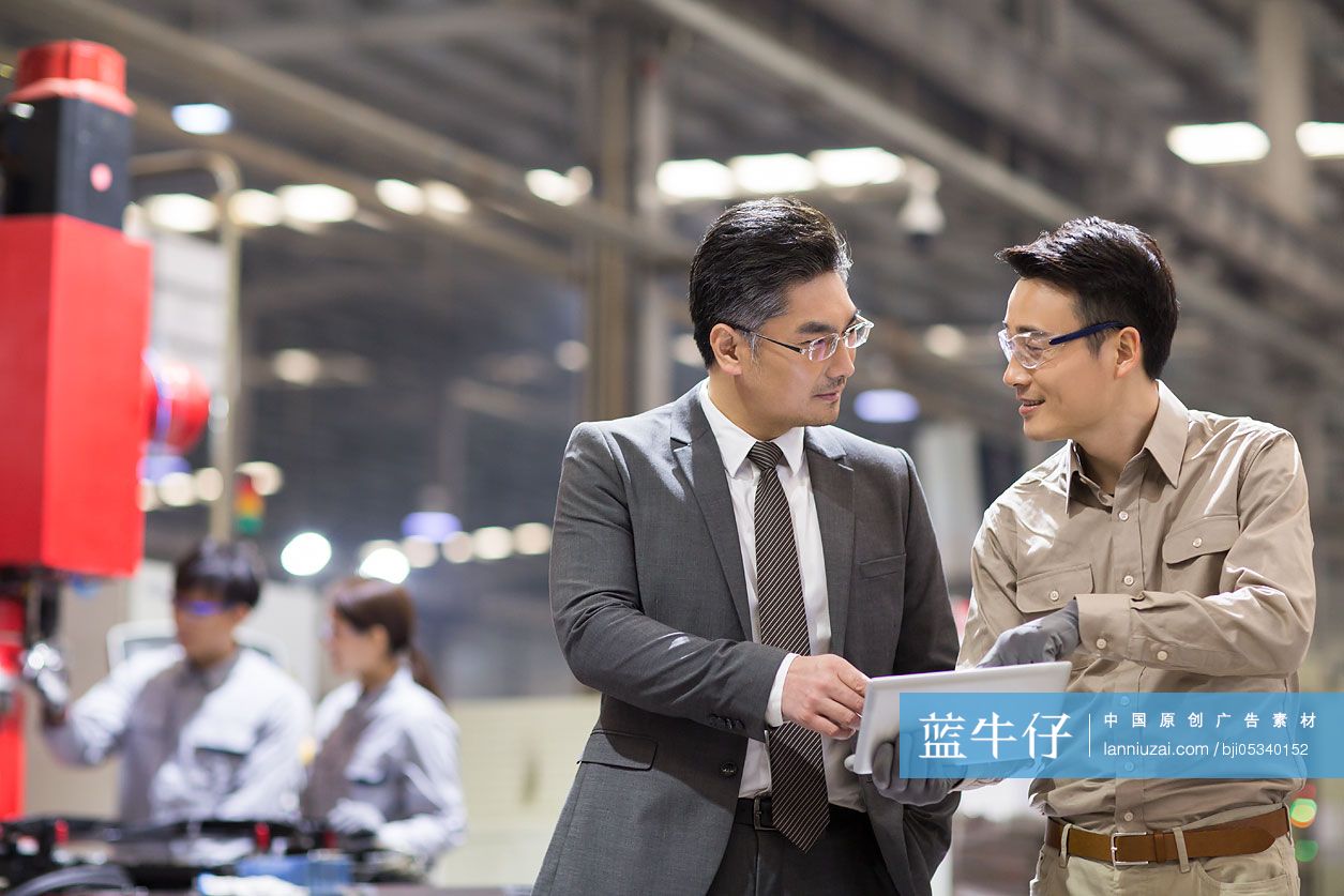 商务男士和工程师在工厂讨论工作