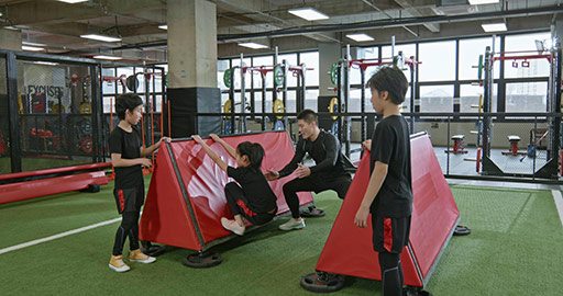 Active Chinese children having exercise class with their coach in gym,4K