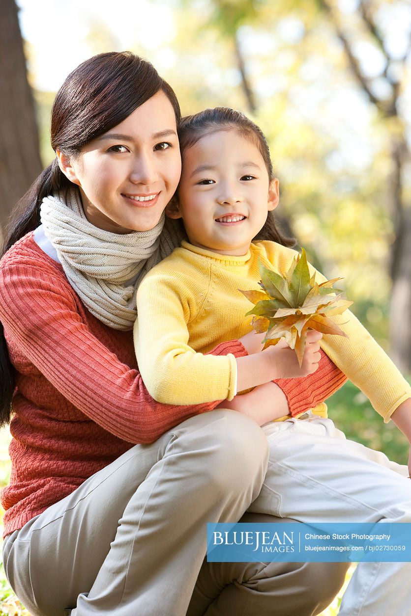 Chinese mother and daughter collecting leaves
